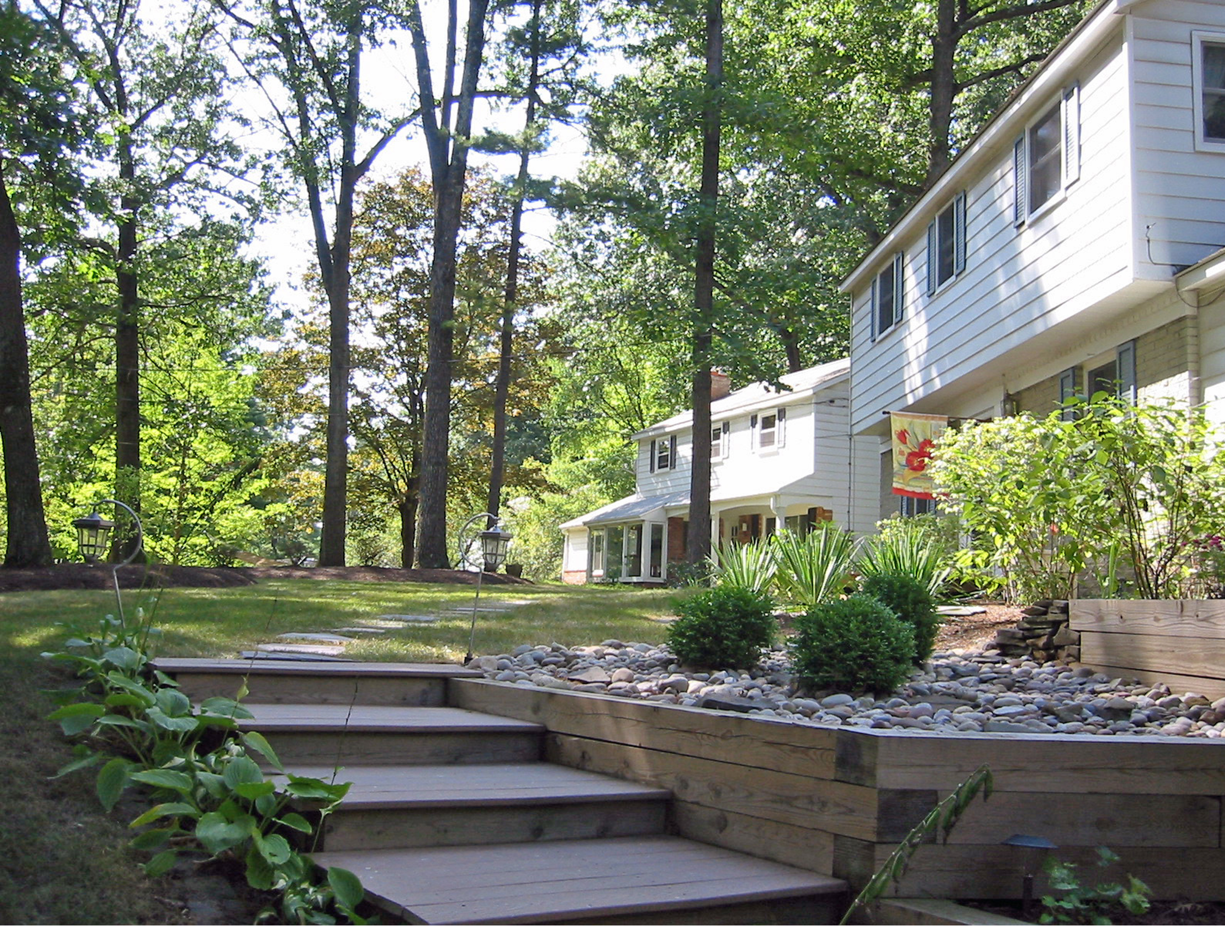 After image of front yard with new plant beds, stone, and stairways