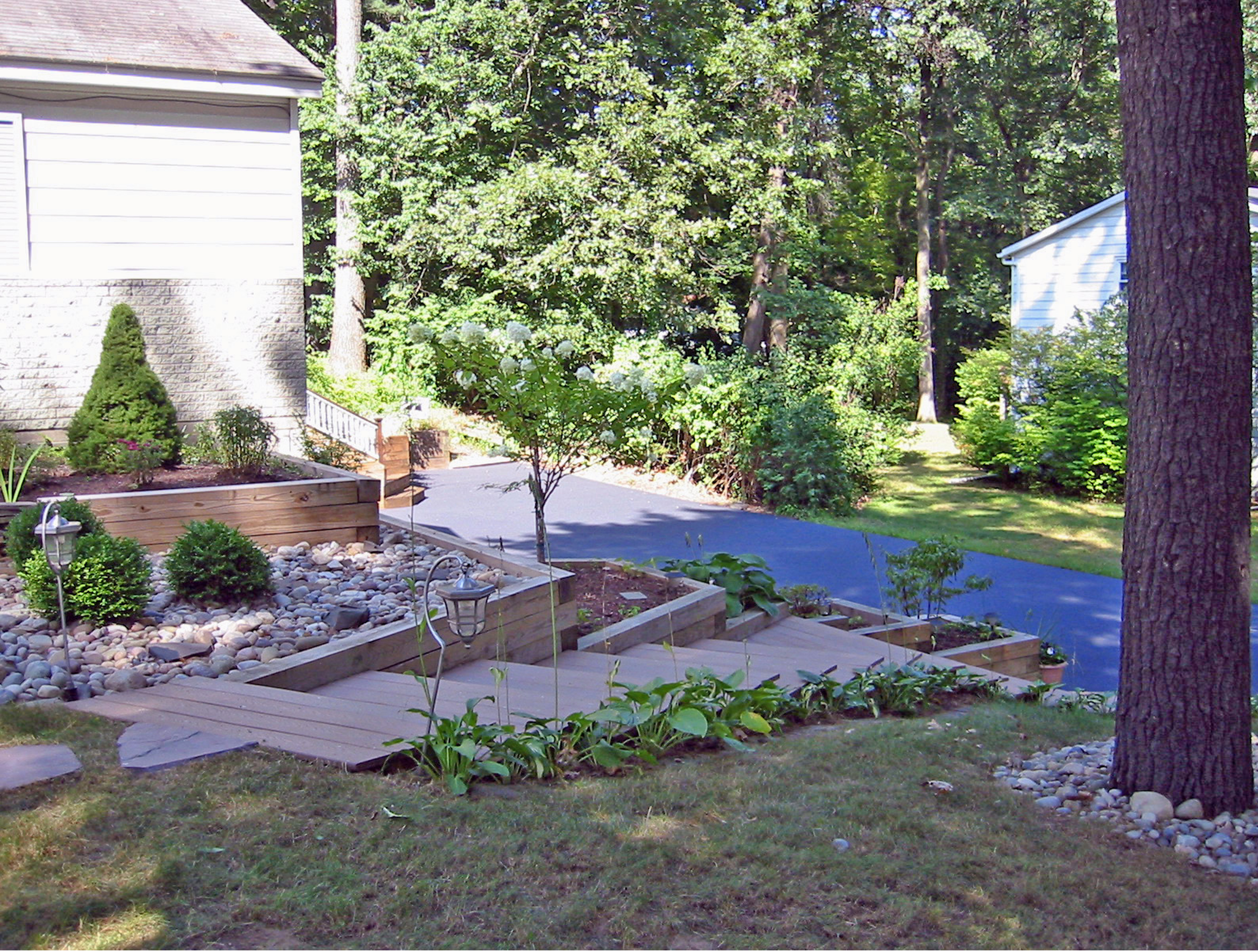 After image of front yard with new plant beds, stone, and stairways