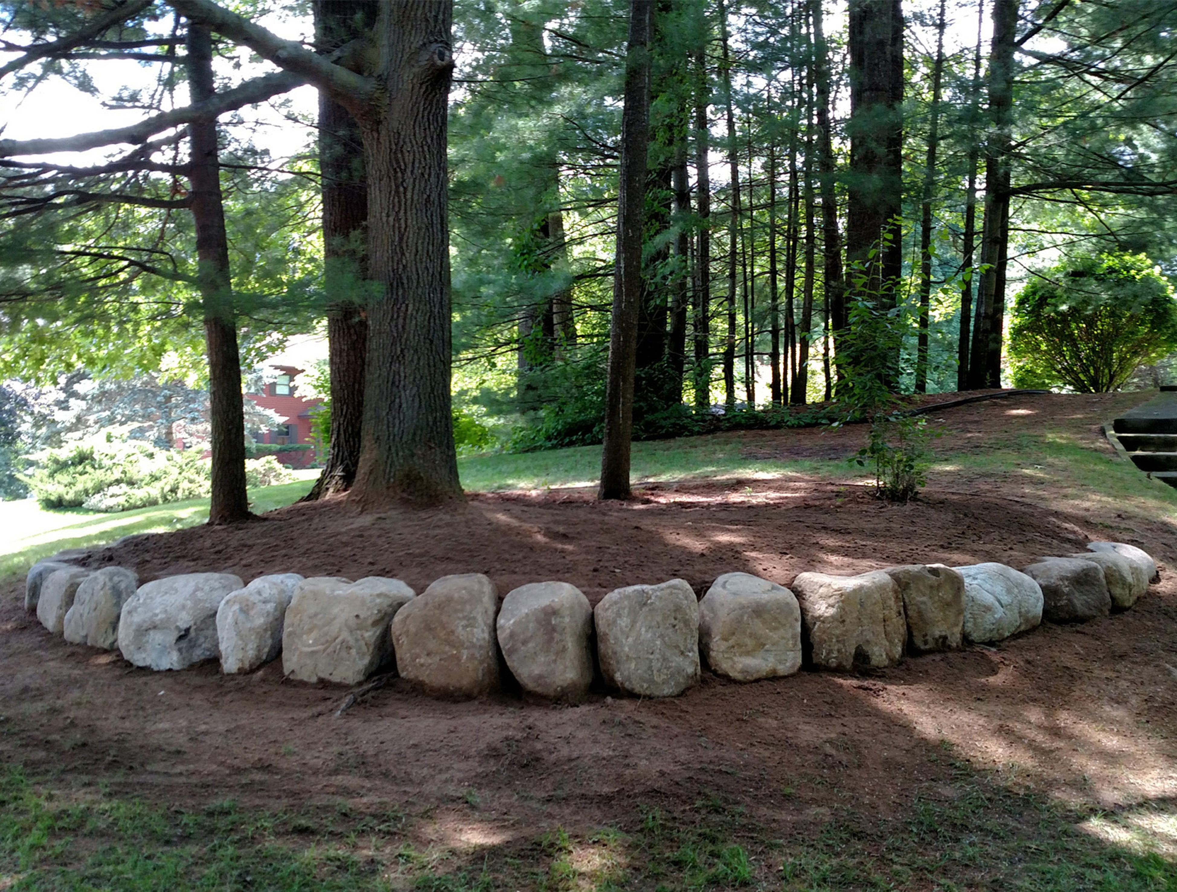 Thumbnail of the right side of the leveled area around the trees and the newly placed stone retaining wall
