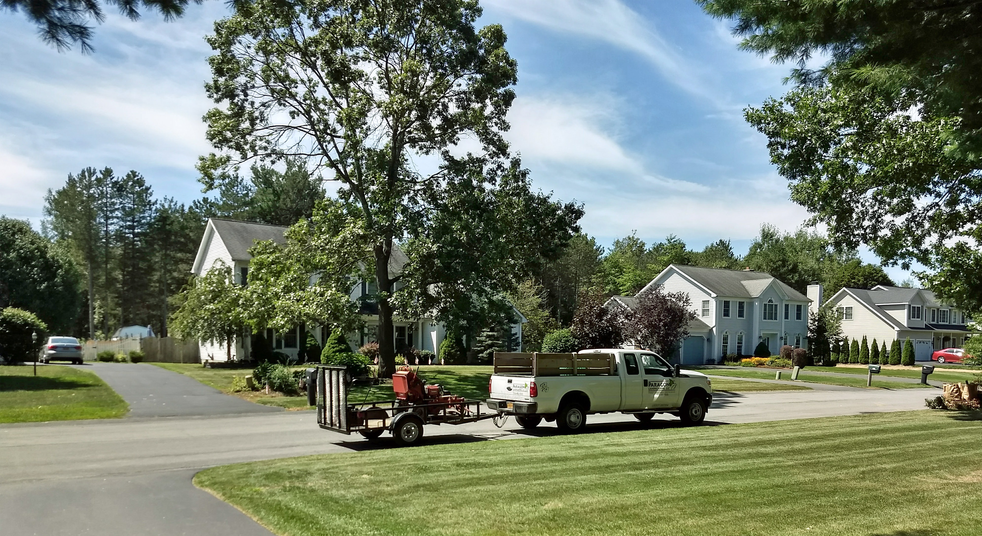 Thumbmnail image of a freshly mowed lawn with work truck and trailer holding a lawn mower
