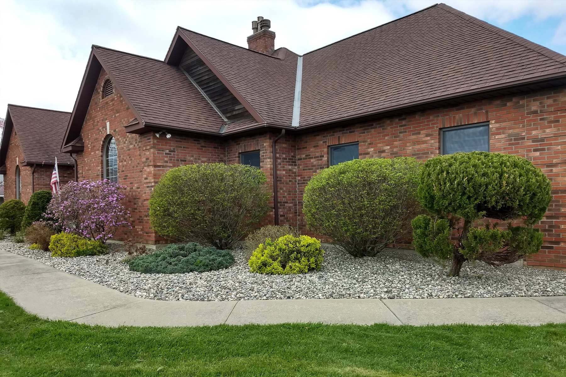 House with stone and plantbeds Spring cleanup